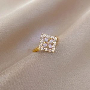 Detailed macro view of a gold square flower ring with pink gems and white zircons