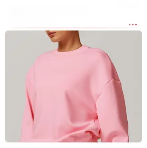 Détail d'un sweat rose à col rond avec épaules tombantes et finitions en bords-côtes