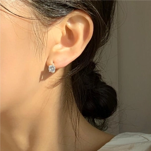 Close-up of minimalist 925 sterling silver four-prong stud earring on model ear
