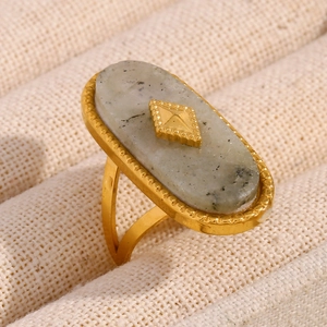 Macro side view of an 18K gold-plated oval white jade ring with vintage metal details