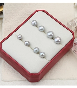 Detailed view of silver-gray freshwater pearls in various sizes inside a red jewelry box