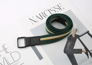 Detail of green striped canvas belt with double D-ring buckle on fashion magazine