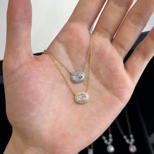 Handheld view of S925 sterling silver oval hollow pendants in gold and silver plating
