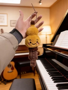 Close-up of a plush gourd instrument toy pendant with embroidery and metal keychain