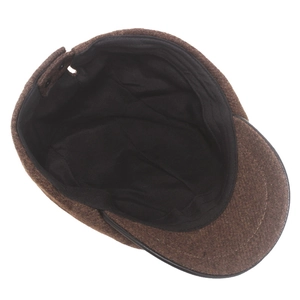 Detail of brown wool newsboy cap showing the black inner lining and adjustable strap
