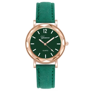 Macro detail of a green quartz watch with rose gold case and suede texture strap