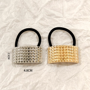 Detail of gold and silver ponytail holders with pyramid rivet texture and dimensions