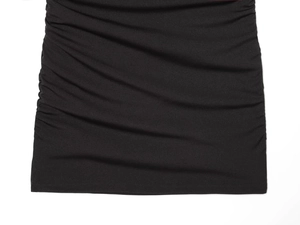 Detailed view of black mesh dress featuring elegant side ruching and fabric texture