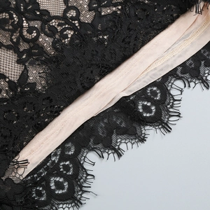 Détail de dentelle noire sur doublure en maille beige avec finition de franges fines