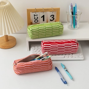 Detail of colorful knitted makeup bags showing striped textures and smooth zippers