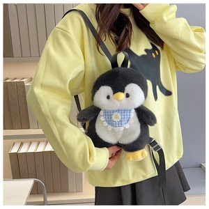 Detail view of a cute plush penguin backpack with floral bib worn over a yellow sweater