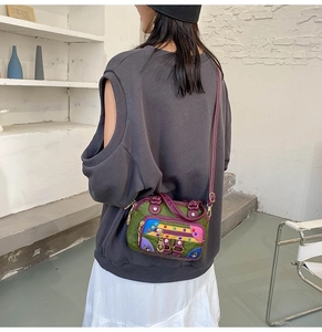 Colorful patchwork crossbody bag with purple strap shown on a model's back