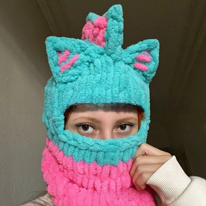 Detailed close-up of handmade crochet balaclava with cat ears in blue and rose pink