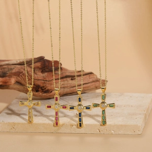 Close-up of hip hop cross necklaces in gold finish with white, red, blue, and green stones