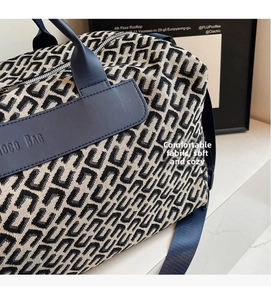 Dettaglio borsa da viaggio con tessuto monogram, finiture in pelle e logo COCO BAG