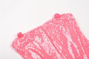 Detail of bright pink sequins fabric and handcrafted floral trim on evening dress