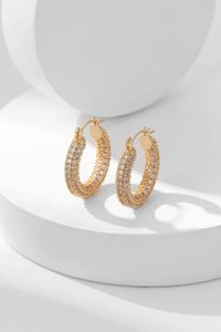 Macro detail of gold hoop earrings with triple rows of micro-paved white zircons