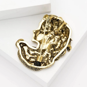 Back view of vintage gold Medusa brooch with detailed relief texture and pin clasp
