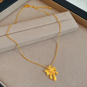 Close-up of gold-plated palm leaf pendant necklace with lobster clasp in a jewelry box