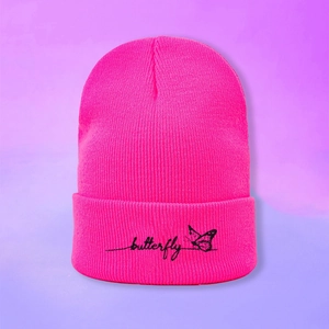 Détail du bonnet en tricot rose fluo avec broderie papillon noire et texte butterfly