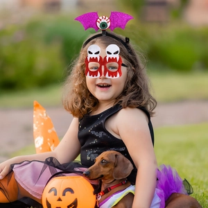 Close-up of sparkling Halloween bat headband and skull eyemask set in outdoor setting
