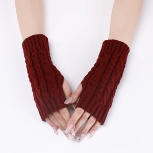 Close-up of wine red cable knit fingerless gloves showing warm winter wrist texture