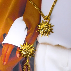 Macro detail of vintage gold-plated sun face tarot necklace with 3D engraved facial features