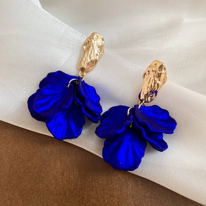 Detail of Klein blue acrylic petal earrings with matte gold hammered texture accents