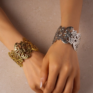 Macro detail of vintage hollow flower bangle with intricate metal gold and silver filigree