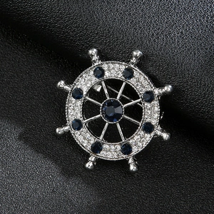 Macro shot of silver nautical helm brooch with blue crystals and sparkling rhinestones