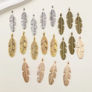 Flat lay of multiple antique alloy leaf charms in gold, silver, bronze, and rose gold finishes
