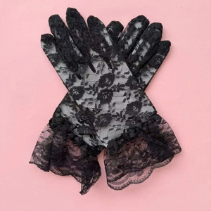 Close-up of floral lace texture and layered ruffle cuffs on black vintage wedding gloves
