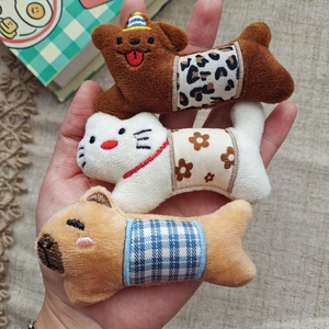 Three plush animal accessories featuring a bear, cat and dog with patterned overalls