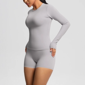 Detail of grey seamless yoga set showing high waist shorts and long sleeve top fit