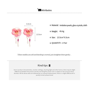 Detail showing pink fabric orchid earrings with imitation pearls and glass crystals