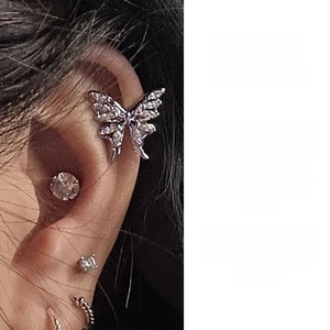 Macro detail of a silver butterfly cartilage earring with pavé-set sparkling zircons