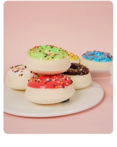 Détails macro de savons en forme de donuts réalistes avec pépites sur fond rose