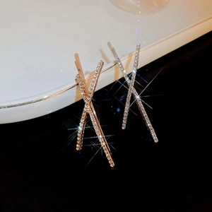 Macro shot of X-shaped crystal hairpins with sparkling rhinestones in rose gold and silver
