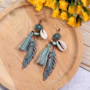 Detail of Bohemian long tassel earrings with turquoise beads and metallic feathers