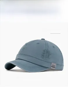 Detail view of dark blue washed cotton baseball cap with grey logo tag and side patches