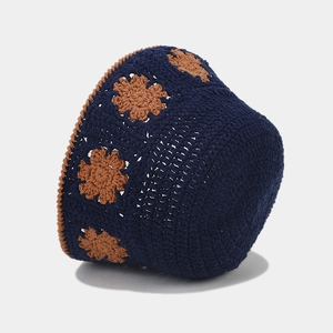 Detail of handcrafted navy crochet bucket hat with intricate brown floral patterns