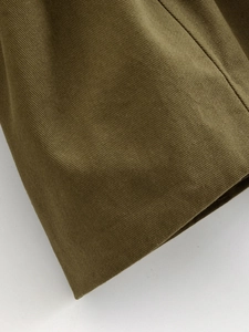 Close-up of olive green twill fabric texture and durable cotton weave on casual jacket