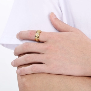 Close-up of golden titanium steel ring with vertical grooves and a single inset diamond