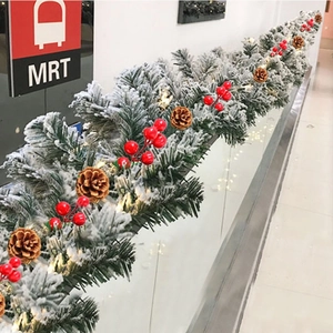 Detail of 9ft Christmas garland with snow needles, red berries, and warm LED lights