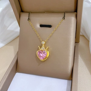 Close-up of pink heart-shaped crystal necklace with gold crown detail in luxury gift box