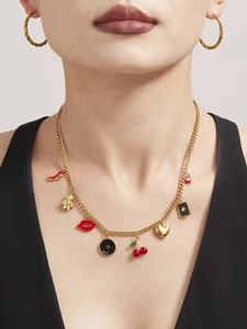 Detail der goldenen Gliederkette mit roten High Heels und Kirsch-Anhängern am Modell