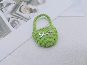 Dettaglio mini borsa verde fatta a mano all'uncinetto con logo e texture