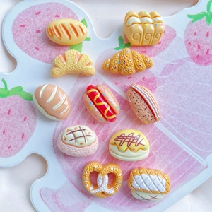 Miniature resin food charms including bread, croissant, and donuts for DIY crafts