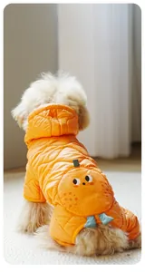 Detail of orange quilted dog winter coat featuring cute cartoon eyes and leaves on the back