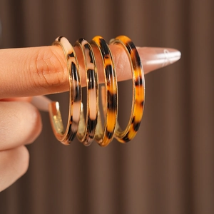 Macro view of C-shaped resin tortoiseshell earrings with elegant gold inner accents
